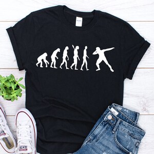 May include: Black t-shirt with a white graphic of the evolution of man ending with a discus thrower.