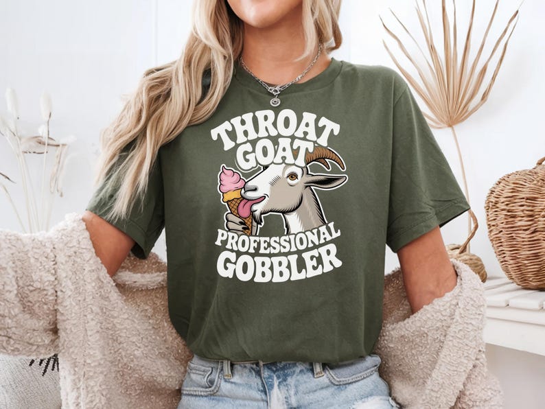 May include: A green t-shirt with a white graphic of a goat eating ice cream. The text on the shirt reads "Throat Goat Professional Gobbler".