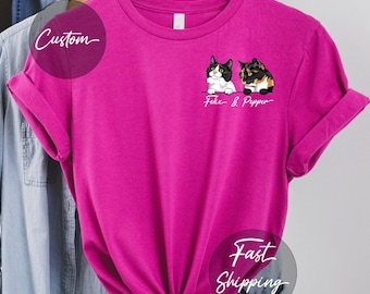 May include: A pink t-shirt with a custom design featuring two cats. The cats are black and white and calico. The text on the shirt reads "Felix & Pepper".