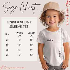 a little girl wearing a white shirt and a brown hat