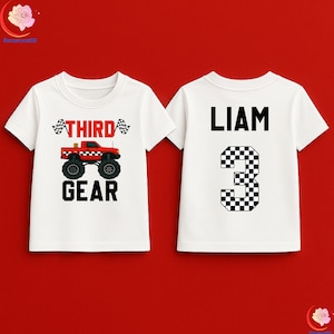 May include: White t-shirt with a red monster truck graphic and the text "THIRD GEAR". The back of the shirt has the name "LIAM" and a checkered number "3".