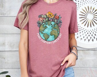 May include: A mauve t-shirt with a graphic of a blue and green earth surrounded by flowers. The text "Make Everyday Earth Day" is printed around the earth.