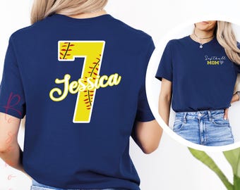 May include: A navy blue t-shirt with a yellow softball number 7 and the name Jessica in white. The back of the shirt has a softball design.