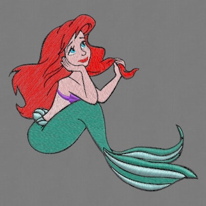 May include: Embroidered illustration of a red-haired mermaid with a green tail and purple seashell bra. The mermaid is sitting with her hand on her chin and looking to the right.