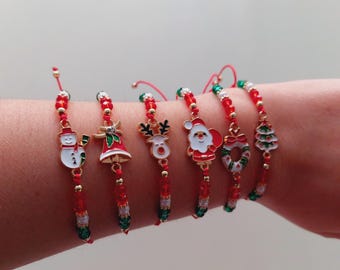 Può includere: Set di sei braccialetti a tema natalizio con perline rosse e verdi e ciondoli. I ciondoli includono un pupazzo di neve, una campana, una renna, Babbo Natale, una ghirlanda e un albero di Natale.