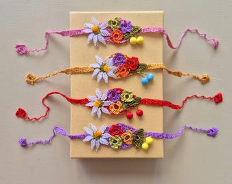 May include: Four crocheted flower bracelets with colorful flowers and beads. The bracelets are on a brown background.