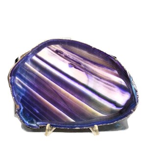 May include: A large, purple agate slice with a natural, striated pattern. The agate is displayed on a metal stand.