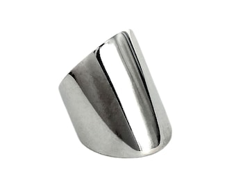 Puede incluir: Un anillo de plata con una banda ancha y plana que está inclinada en un ángulo de 45 grados.