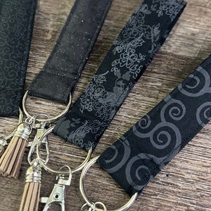 Llavero de pulsera negro y gris con borlas, clip de langosta, brillos plateados, algodón, cordón floral, llavero de pulsera negro hecho a mano.