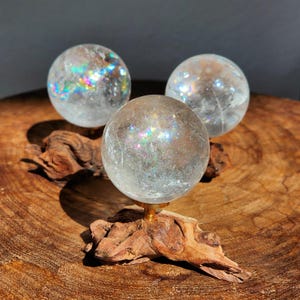 Lemurian Quartz sphere filled with strong rainbows. Clear and high quality quartz sphere that will bring the healing properties of this Master Healer. Measuring approximately 2.2" across, sold without stand. Perfect for your crystal collection.