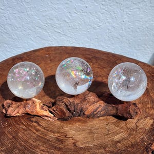 Lemurian Quartz sphere filled with strong rainbows. Clear and high quality quartz sphere that will bring the healing properties of this Master Healer. Measuring approximately 2.2" across, sold without stand. Perfect for your crystal collection.
