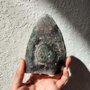 Raw Grey Amethyst with staclatite  from the mines of Brazil. Very much in it's natural raw state, this unique collector's piece comes with a customised wooden base. stands about 6inches tall.