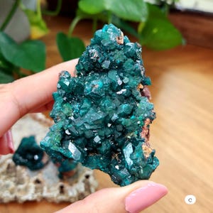 May include: A cluster of vibrant green crystals with a rough, natural texture. The crystals are arranged in a pyramid shape, creating a visually appealing and unique piece.