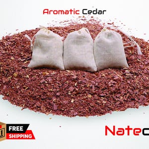 May include: Three white fabric pouches filled with cedar wood chips. The pouches are arranged in a row on a bed of red cedar wood chips. The text "Aromatic Cedar" is written in red letters above the pouches.