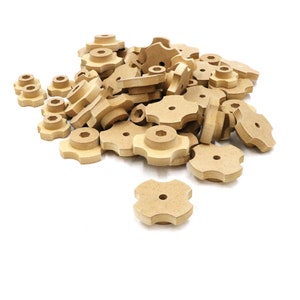 May include: A pile of unfinished wooden knobs with a five-pointed star shape. The knobs are light brown and have a hole in the center.