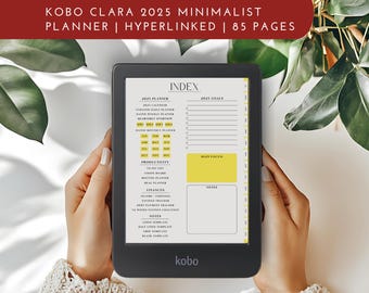 Peut inclure: Une liseuse noir et blanc avec un écran affichant un index de planificateur 2025. L'index comprend des sections pour la planification quotidienne, hebdomadaire et mensuelle, ainsi que la productivité, les finances et les notes. La liseuse est étiquetée "kobo" et a un design minimaliste.