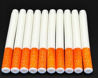 Op de afbeelding: Een set van tien cilindervormige objecten op een rij, elk met een glad wit bovendeel en een textuurrijke oranje basis die op een filter lijkt. De objecten zijn uniform van vorm en grootte, met een holle opening aan de onderkant.