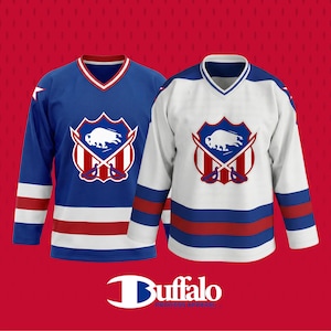 May include: Two hockey jerseys, one blue and one white, with a Buffalo logo. The blue jersey has white and red stripes on the sleeves and bottom. The white jersey has blue and red stripes. Both jerseys have a V-neck collar.