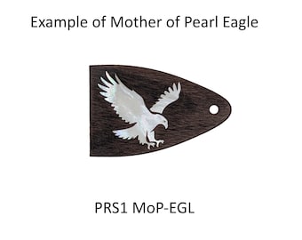 May include: A triangular dark brown wooden guitar truss rod cover featuring an inlaid iridescent white mother of pearl eagle design and a single circular mounting hole. The text Example of Mother of Pearl Eagle and PRS1 MoP-EGL is visible.