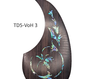 May include: A dark brown teardrop-shaped acoustic guitar pickguard featuring an iridescent abalone shell inlay in a floral pattern. The text TD5-VoH 3 is printed in black on the left side of the wooden surface, which has a visible grain.