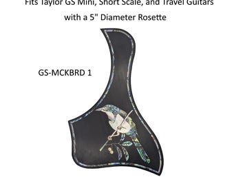 May include: A black guitar pickguard with an iridescent abalone inlay depicting a bird perched on a branch. The text reads: Fits Taylor GS Mini, Short Scale, and Travel Guitars with a 5" Diameter Rosette and GS-MCKBRD 1. The border is inlaid.