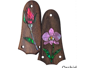 May include: Two dark brown wooden guitar truss rod covers with iridescent shell inlays. One cover features a red rose design with green leaves, labeled Rose. The other cover features a purple orchid design with green leaves, labeled Orchid.