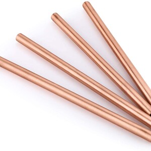 May include: Four rose gold reusable metal drinking straws. The straws are made of stainless steel and are a popular eco-friendly alternative to plastic straws.