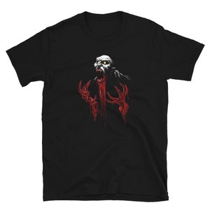 Puede incluir: Camiseta negra con un gráfico de una criatura de piel pálida gritando, con manos rojas y sangrientas y una boca sangrienta. La criatura tiene ojos amarillos y pelo oscuro. El diseño está centrado en la parte delantera.