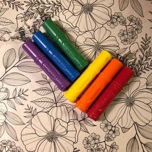 May include: Rainbow coloured marker earrings. The earrings are made from Crayola markers and have silver hooks. The earrings are on a white background with a black floral pattern.