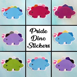May include: A collection of Pride Dino stickers in various colors, including blue, red, purple, and green. Each sticker features a cartoon dinosaur with a rainbow-colored spine and heart accents. The text "Pride Dino Stickers" is in the center.