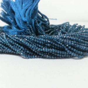 Op de afbeelding: Een streng blauwe facetgeslepen edelsteen kralen. De kralen zijn klein en rond en hebben een glanzende, metallic afwerking.