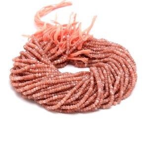 May include: A strand of peach-coloured sunstone beads, approximately 4mm in size, with a faceted finish. The beads are strung on a thin, orange thread and are ready for jewellery making.