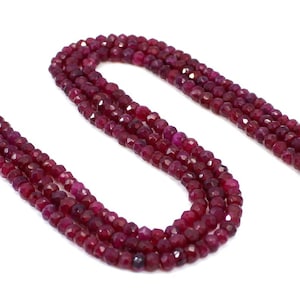 May include: A strand of deep red ruby beads, faceted and polished, strung together to create a necklace or bracelet. The beads are uniform in size and shape, creating a consistent and elegant look.