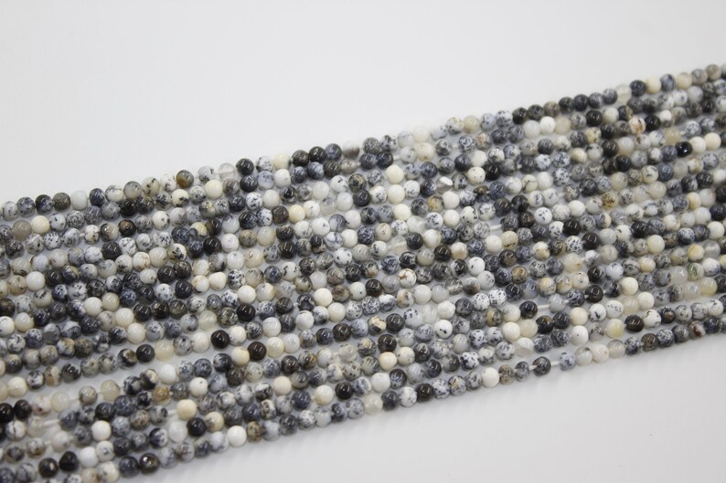 May include: A strand of round, white, black, and brown speckled beads. The beads are approximately 4mm in diameter and have a natural, polished finish.