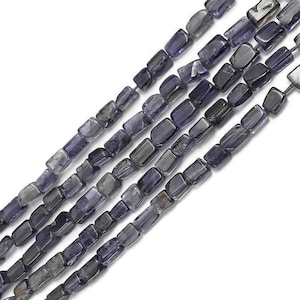 May include: A strand of dark blue, faceted, gemstone beads. The beads are rectangular in shape and have a slightly irregular, natural look.
