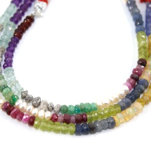 Könnte beinhalten: Eine mehrreihige Halskette mit verschiedenen Edelsteinperlen, darunter Amethyst, Aquamarin, Smaragd, Rubin, Saphir und Opal. Die Halskette enthält auch weiße Perlen und facettierte Diamantperlen.