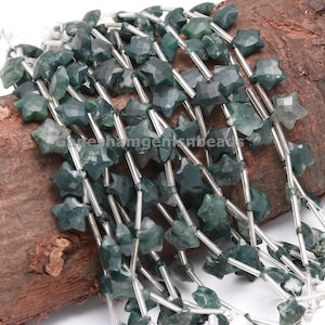 May include: Close-up of star-shaped green moss agate beads. The faceted beads have varying shades of green. Strung on silver-coloured wire, these beads are ideal for crafting jewellery.