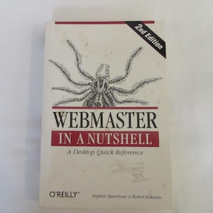 Puede incluir: Un libro titulado "Webmaster in a Nutshell: A Desktop Quick Reference" de Stephen Spainbour y Robert Eckstein. La portada del libro presenta una ilustración en blanco y negro de una araña.