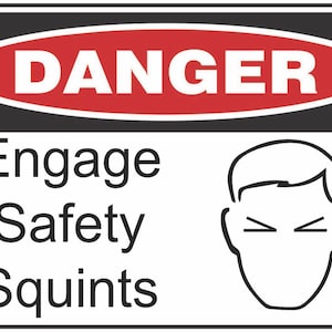 May include: A white and black safety sign with a red oval that says "DANGER" in white letters. The sign says "Engage Safety Squints" in black text and has a black line drawing of a person squinting.
