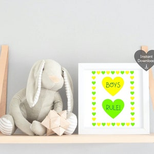 May include: A white framed print with the words "BOYS RULE!" in yellow and green hearts. A soft grey bunny and a wooden geometric toy sit on a wooden shelf with leather straps, suitable for a child's room.