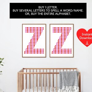 May include: Two framed prints of the letter "Z", each made up of red and pink heart shapes on a white background. The prints are displayed on a white wall, with a cot and plant in the foreground. Text above reads: "BUY 1 LETTER. BUY SEVERAL LETTERS TO SPELL A WORD/NAME. OR, BUY THE ENTIRE ALPHABET."