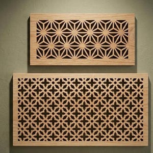 Può includere: Due pannelli rettangolari in legno chiaro con intricati motivi geometrici tagliati al laser. Il pannello superiore mostra un design a reticolo a forma di stella, mentre quello inferiore presenta un denso motivo floreale a quattro punte.