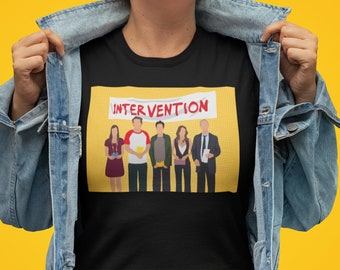 Puede incluir: Camiseta negra con fondo amarillo que presenta un grupo de personajes de dibujos animados y el texto "INTERVENTION".