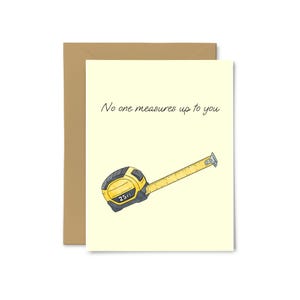 May include: Greeting card with a yellow background and a cartoon tape measure. The tape measure is yellow and black, with the text "25 FT" on the front. The card reads "No one measures up to you."
