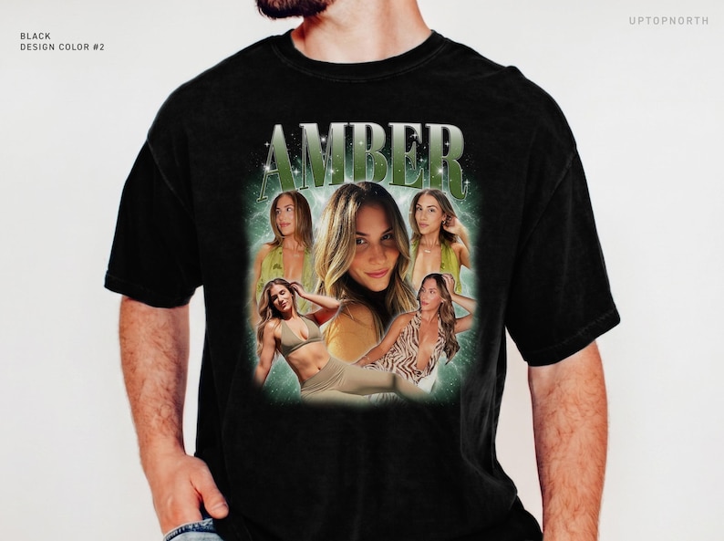 May include: A black short-sleeve t-shirt featuring a graphic print with the name AMBER in large green letters at the top. The design includes a collage of four photographs of a woman in various poses, set against a glowing green background.
