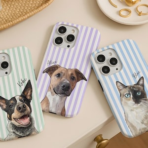 May include: Three smartphone cases featuring custom pet portraits. The left case has a mint green striped background with a dog named Kobe. The center case has a lavender striped background with a dog named Alice. The right case has a light blue striped background with a cat named Blue.