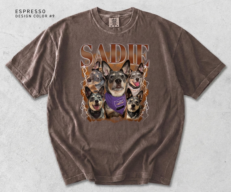 Pu&ograve; includere: T-shirt color espresso con il nome "SADIE" in un carattere marrone invecchiato. La maglietta presenta una grafica di cinque cani, uno dei quali indossa una bandana viola. Il design include accenti di fulmini.
