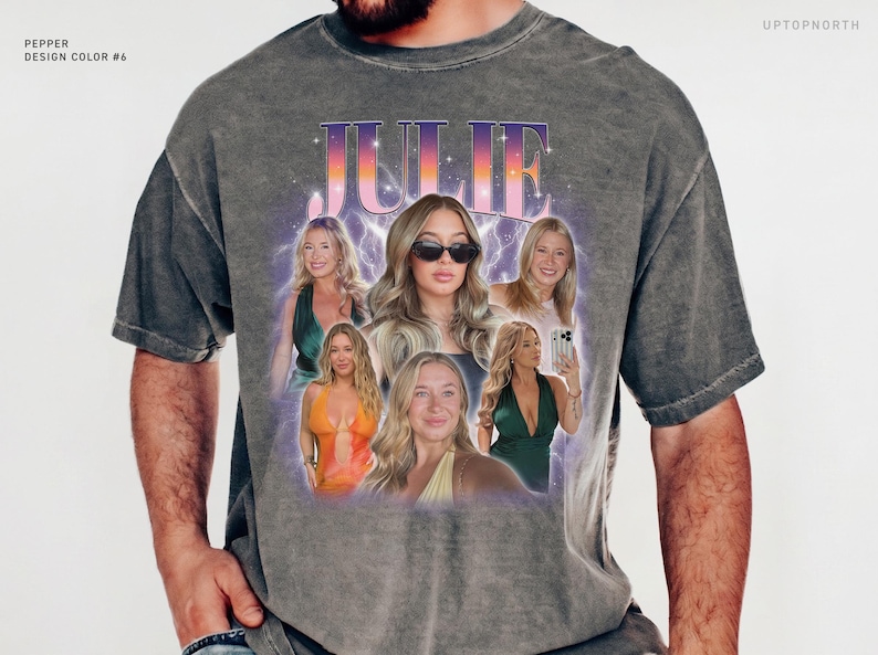 May include: A charcoal gray short-sleeve t-shirt featuring a graphic print with the name JULIE in a gradient font. The design includes multiple photographic portraits of a person, surrounded by a purple lightning effect and stars.