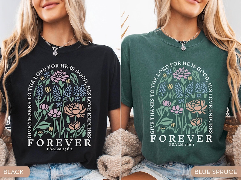 May include: Black and blue spruce t-shirts with floral designs and the text "GIVE THANKS TO THE LORD FOR HE IS GOOD, HIS LOVE ENDURES FOREVER PSALM 136:1". The shirts feature a floral arch design with various flowers.