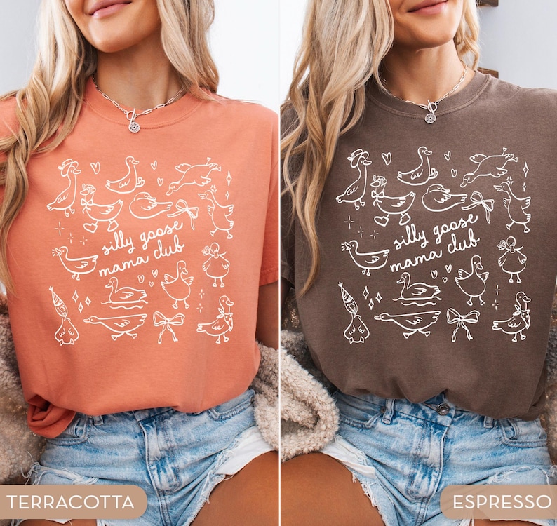 May include: Two t-shirts, one terracotta and one espresso, each featuring a white graphic of cartoon geese and the text "silly goose mama club." The shirts are short-sleeved and appear to be made of a soft material.